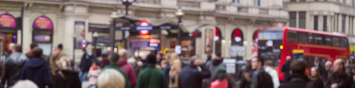 London street showing Londoners and tourist, London red bus, Underground sign and theatre sign