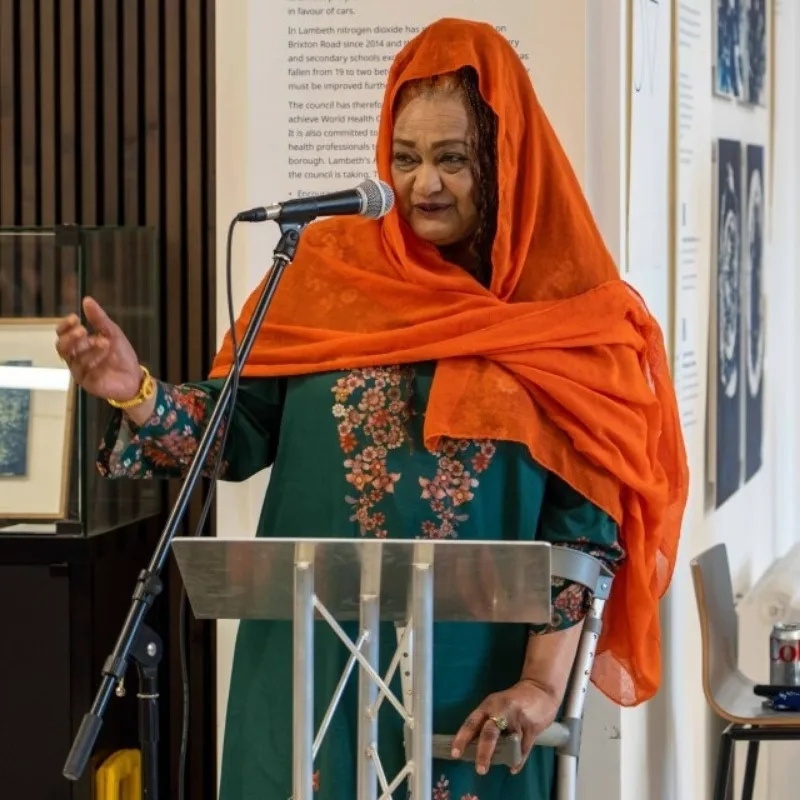 A woman in a hijab speaking into a microphone.
