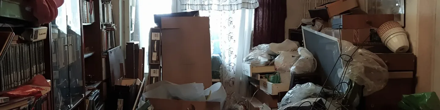 A cluttered room filled with boxes and mess.