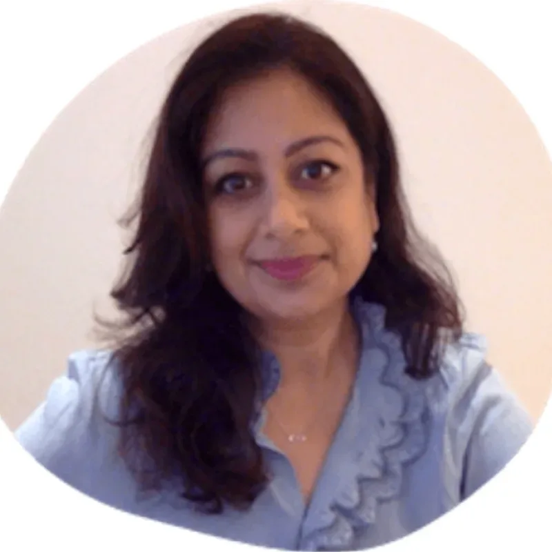 A woman with long dark hair, wearing a light blue blouse with a sliver neckline, smiling.