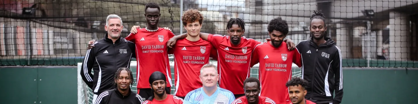 A group of men wearing red football kits stand together, showcasing team spirit.