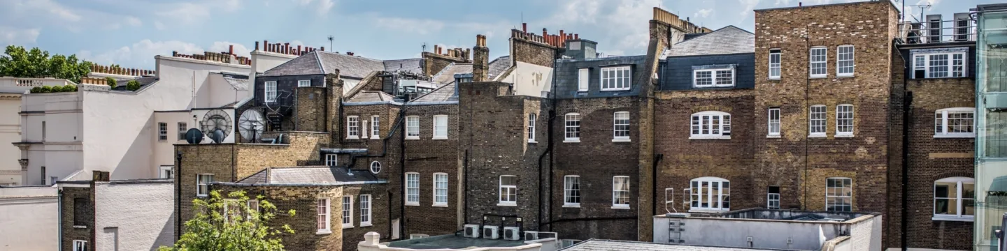 A view of the city from above, featuring rooftops and the blue sky.