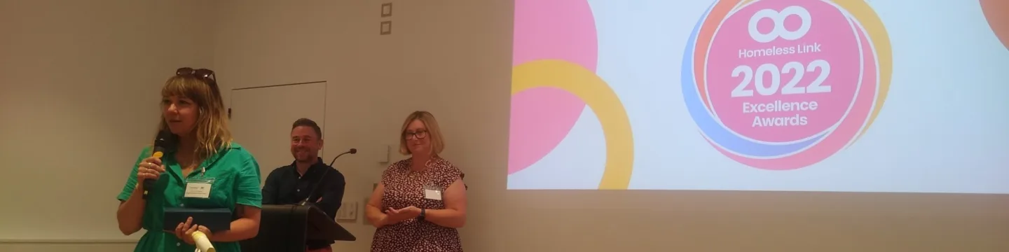 A woman stands confidently at a podium, preparing to deliver a speech or presentation to an audience.