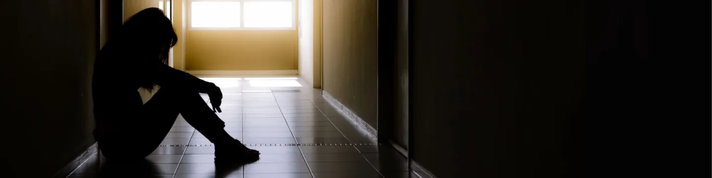 Girl sits lonely in dark corridor