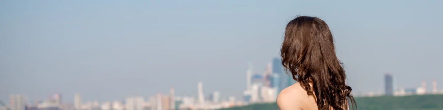 Girl on the background of the city landscape on the mountain