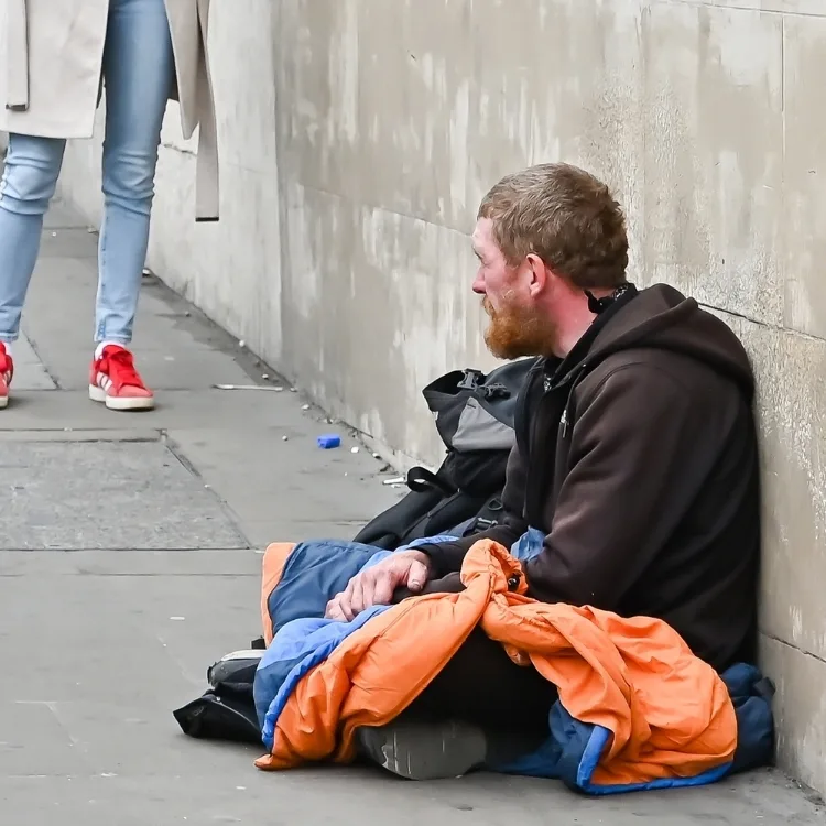 Man with sleeping bag homeless on the street